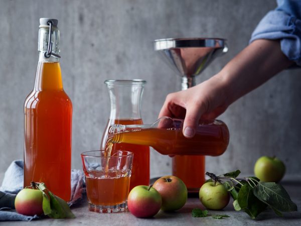 Flaskor och glas fyllda med äppelmust.