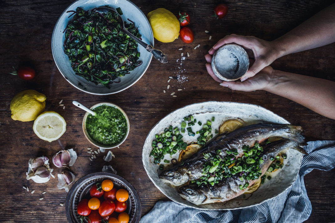 Ett bord med massor av gott; fisk, fräst mangold och andra tillbehör.