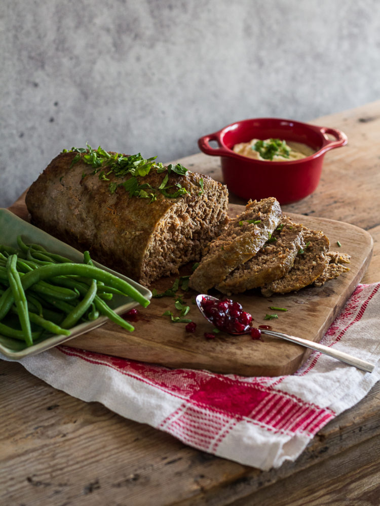 En fin köttfärslimpa ligger upplagd på ett fint träskärdbräde.