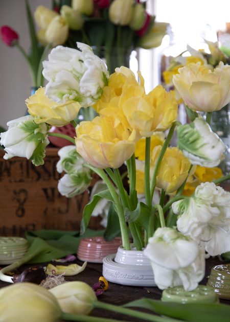 Ett gult och vitt tulpanarrangemang i blomhållare.